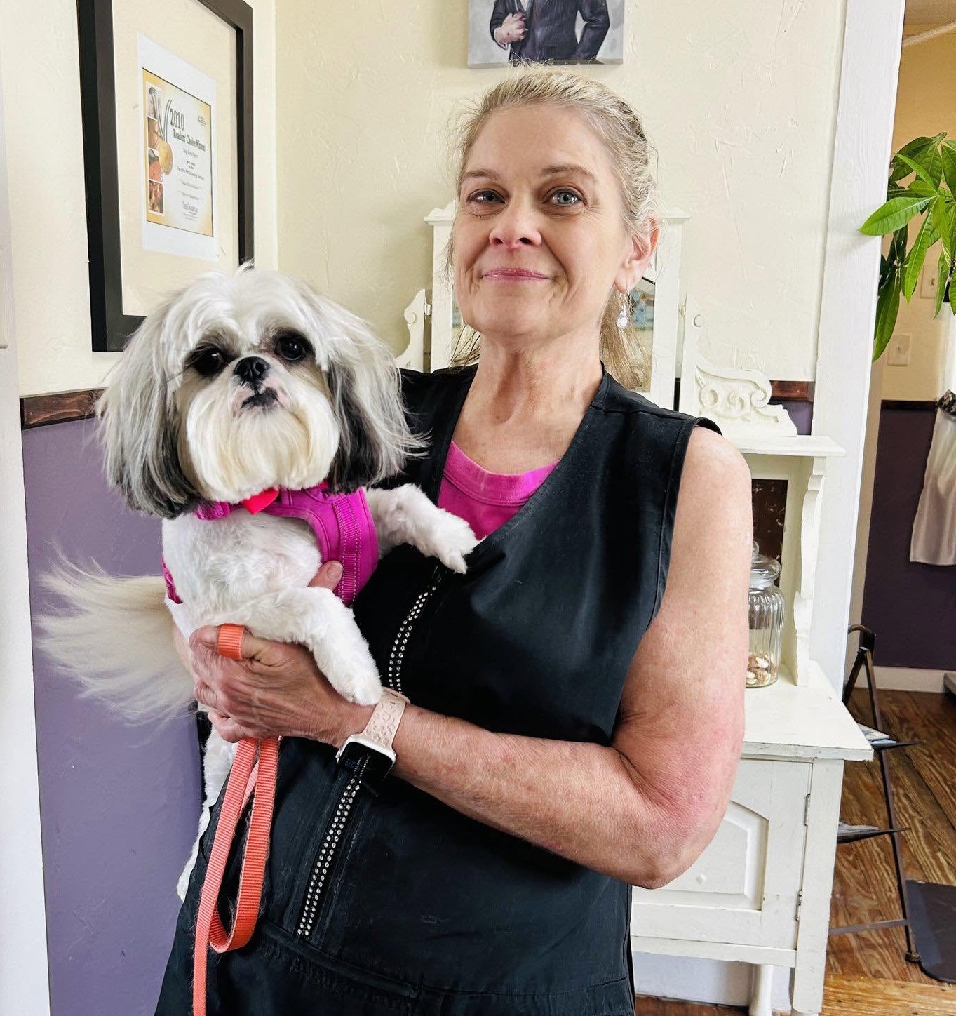 Owner Lisa Roberds holding a freshly groomed dog inside the Dog Gone Stylin salon